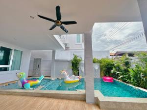a living room with a swimming pool with a ceiling fan at Rosewood Pool Villa Pattaya 3 in Pattaya South