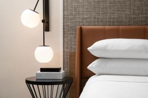 a bedroom with two lamps on a bed and a side table at Sheraton Fort Worth Downtown Hotel in Fort Worth