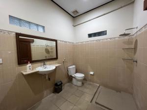 La salle de bains est pourvue de toilettes, d'un lavabo et d'un miroir. dans l'établissement Nari Homestay, à Canggu