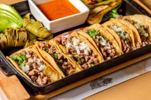 a tray of food with tacos and dips at Camino Real Aeropuerto in Mexico City