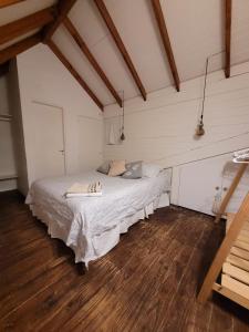 1 dormitorio con 1 cama en una habitación con suelo de madera en La Cabaña en Puerto Madryn