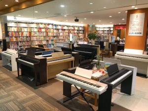 市川市留连之家，隣東京的千葉県市川生活交通便利经济型旅馆、适合家庭游使用！可根据予约配置婴幼儿床及老人推椅。的中间有几架钢琴的图书馆