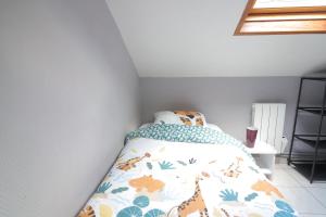 una camera da letto con un letto e un copriletto con animali di Cocooning chelles Disneyland Paris a Chelles