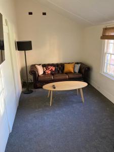 uma sala de estar com um sofá e uma mesa de centro em The Tamarisks at Rosevale em Bathurst