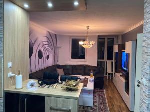 Luxapartment Doha في سراييفو: غرفة معيشة مع أريكة وطاولة