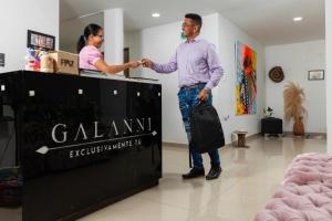 Ein Mann und eine Frau schütteln Hand in einem Laden in der Unterkunft Hotel Galanni in Valledupar