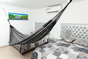 a hammock in a bedroom with two beds at Hotel Galanni in Valledupar
