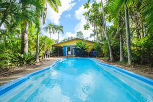 uma piscina em frente a uma casa com palmeiras em Getaways at Byfield em Byfield