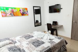 a bedroom with a bed with a quilt on it at Hotel Galanni in Valledupar