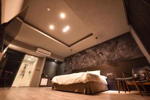 1 dormitorio con 1 cama en una habitación con sillas en Two Couples Leisure Art Motel en Tainan