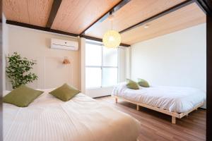 a bedroom with two beds and a large window at 【鶴木宿】 in Osaka