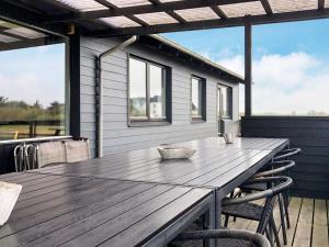 a wooden table on the deck of a house at 4 star holiday home in Harboøre-By Traum in Harboør