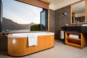 
a bath room with a tub and a sink at Azur Lodge in Queenstown
