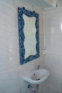 baño con lavabo y espejo en la pared en Secret Joglo Lebih, en Lebih