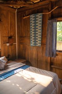 een slaapkamer met 2 bedden en een raam bij Secret Joglo Lebih in Lebih