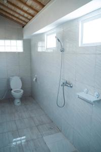 een badkamer met een douche en een toilet bij Secret Joglo Lebih in Lebih