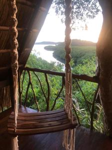 a swing in a tree house with a view of a river at Sanctuaria Treehouses Busuanga in Busuanga