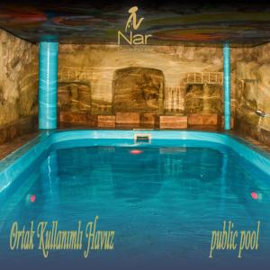 a swimming pool in a building with blue water at Cappadocia Nar Cave House & Hot Swimming Pool in Nevsehir