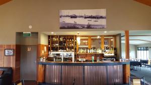 a bar in a restaurant with a large room at Stations Inn in Hokitika