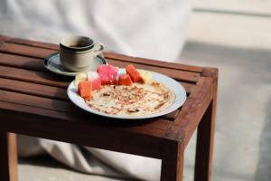 a plate of food and a cup of coffee on a table at Lala Salama Backpacker in Teluknarat