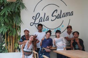a group of people standing in front of a sign at Lala Salama Backpacker in Teluk Nara