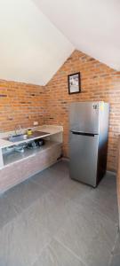 uma cozinha com um frigorífico de aço inoxidável numa parede de tijolos em La ROBLEDA CASA DE CAMPO em Zapopan