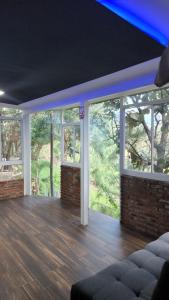 uma sala de estar com janelas grandes e piso em madeira em La ROBLEDA CASA DE CAMPO em Zapopan