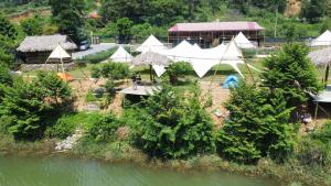 an aerial view of a group of tents next to a river at Lagom Village (Glamping Site) in Hanoi