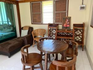 een woonkamer met een tafel en stoelen en een bank bij Baanpak Chomdoi in Nan