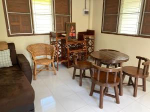 een woonkamer met houten tafels en stoelen bij Baanpak Chomdoi in Nan