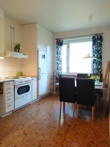 a kitchen with a table and chairs and a window at Arthome Oxelösund in Oxelösund