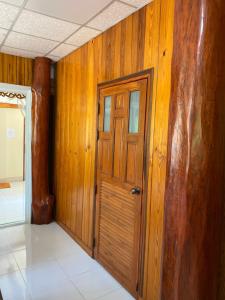 een deur in een kamer met houten wanden bij Baanpak Chomdoi in Nan