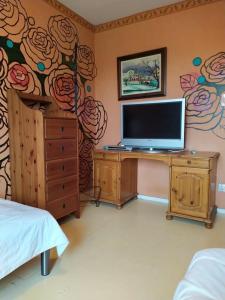 a bedroom with a tv on a desk with a flower mural at Arthome Oxelösund in Oxelösund