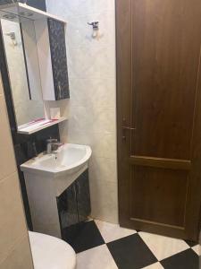 Cozy Apartment في تبليسي: حمام مع حوض ومرحاض ومرآة