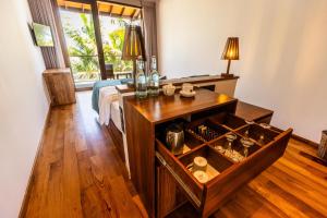 a bedroom with a bed and a table with a drawer at BK Beach Boutique Hotel - Hikkaduwa in Hikkaduwa