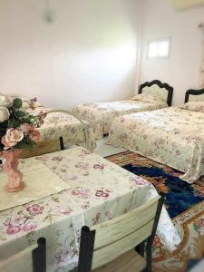 a room with three beds and a vase with flowers at Daddy's homestay in Ban Bang Krasan