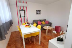a living room with a white table and yellow chairs at Happy Dreams Apartment near the beach and old town in Split