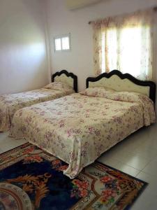 a bedroom with two beds and a rug at Daddy's homestay in Ban Bang Krasan