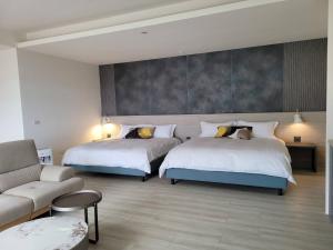 una camera d'albergo con due letti e un divano di Slowly B&B a Jiufen