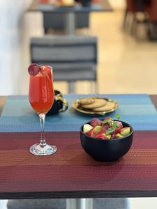 Guided Hospitality - Luxury Accommodations في لاغوس: وعاء من الفاكهة ومشروب على الطاولة