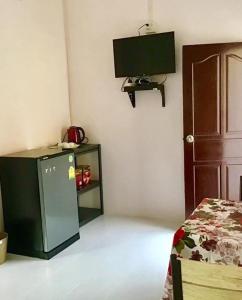 a room with a refrigerator and a tv on the wall at Daddy's homestay in Ban Bang Krasan