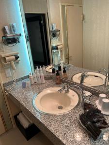 a bathroom counter with two sinks and a mirror at Hotel AKAIKUTSU - Adult Only in Yokohama