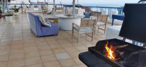 a fireplace on a patio with a table and chairs at Egeon Studios in Neos Marmaras
