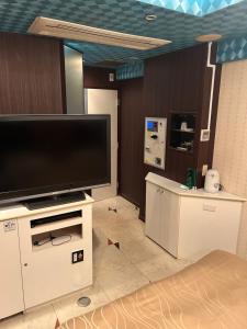 Hotel AKAIKUTSU - Adult Only في يوكوهاما: غرفة معيشة مع تلفزيون بشاشة مسطحة كبيرة