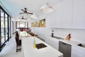 eine Küche mit weißen Arbeitsplatten und ein Esszimmer in der Unterkunft My Khe Beach Villa in Đà Nẵng