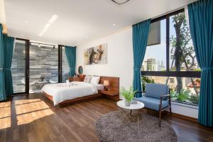 a bedroom with a bed and a blue chair at Green My Khe Beach Villa in Da Nang +113 photos