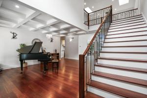 a living room with a piano and a staircase at Luxurious Mansion, Deck, Patio, Chef’s Kitchen in Crown Point