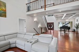 a living room with a white couch and a piano at Luxurious Mansion, Deck, Patio, Chef’s Kitchen in Crown Point