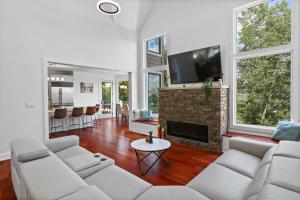 a living room with white furniture and a fireplace at Luxurious Mansion, Deck, Patio, Chef’s Kitchen in Crown Point
