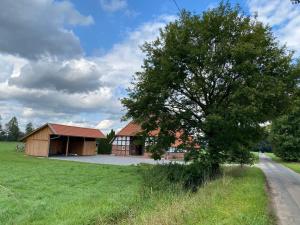 a building with a tree in front of it at Heuerhaus - Artlands Home- Landhaus für Familien und Gruppen in Badbergen